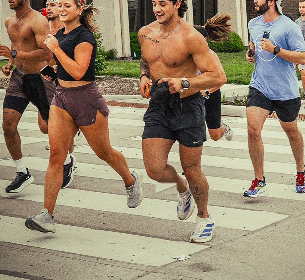 Omen Athletics run club crossing a downtown St. Louis street on a Saturday morning.
